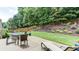 Patio featuring an outdoor dining area and lounge chair with a landscaped backyard view at 1810 Stardust Trl, Cumming, GA 30040