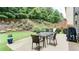 Outdoor patio with dining table and chairs, grill, and landscaped backyard with wooded backdrop at 1810 Stardust Trl, Cumming, GA 30040