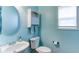 Bright bathroom with circular mirror, a toilet, and a window at 1810 Stardust Trl, Cumming, GA 30040