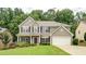 Traditional two-story home with a well-maintained lawn, inviting front porch, and two-car garage at 1810 Stardust Trl, Cumming, GA 30040