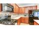 Close up of the kitchen appliances and cherry wood cabinetry and tiled backsplash at 1810 Stardust Trl, Cumming, GA 30040