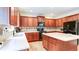 Open kitchen featuring cherry wood cabinets, island, tiled backsplash, and black appliances at 1810 Stardust Trl, Cumming, GA 30040