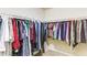 Large walk-in closet with ample hanging space on multiple rods and neutral carpeting at 1810 Stardust Trl, Cumming, GA 30040