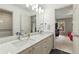 Bright bathroom with double vanity, marble countertop, and an open doorway view of bedroom at 2055 Beacon Hill Way, Alpharetta, GA 30005