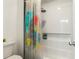 Bright bathroom with a shower-tub combo with colorful shower curtain and built-in shelving at 2055 Beacon Hill Way, Alpharetta, GA 30005