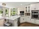 Open kitchen with white cabinets, modern appliances and view into the living room at 2055 Beacon Hill Way, Alpharetta, GA 30005