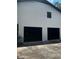 Attached two-car garage featuring modern, black door on a white brick building at 2475 Cajun Dr, Marietta, GA 30066