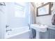 Bright bathroom with white subway tile, pedestal sink, and grey shower curtain at 401 Emory Ne Dr, Atlanta, GA 30307