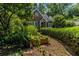 Brick home surrounded by lush landscaping, including mature trees, bushes, and potted plants at 401 Emory Ne Dr, Atlanta, GA 30307