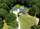 Expansive aerial view showcasing a wooded property with detached garage and circular drive at 5300 Haynes Creek Dr, Loganville, GA 30052