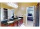 Elegant primary bathroom with dual sinks, large mirror, and doorway leading to bedroom suite at 5300 Haynes Creek Dr, Loganville, GA 30052