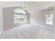 Bright bedroom featuring large windows, plush carpeting, and a ceiling fan for comfortable living at 5300 Haynes Creek Dr, Loganville, GA 30052