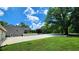 Spacious yard and driveway leading to a tan home with an attached garage beneath a bright, partly cloudy sky at 5300 Haynes Creek Dr, Loganville, GA 30052