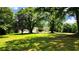 Expansive front yard with mature trees, a long driveway, and a view of the house and garage at 5300 Haynes Creek Dr, Loganville, GA 30052