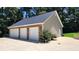 Three-car garage with stone veneer, attached to a tan home at 5300 Haynes Creek Dr, Loganville, GA 30052