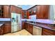 Well-lit kitchen featuring stainless steel appliances and rich, dark cabinetry with granite countertops at 5300 Haynes Creek Dr, Loganville, GA 30052