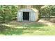 Storage shed on a grassy lot enclosed by wooden fence, offering practical outdoor storage solutions at 5300 Haynes Creek Dr, Loganville, GA 30052