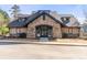 Community clubhouse with stone and siding, featuring double doors and manicured landscaping at 1865 Ellison Lakes Nw Ct # 21, Kennesaw, GA 30152