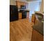 Well-equipped kitchen with stainless steel appliances, laminate flooring, and black countertops at 1865 Ellison Lakes Nw Ct # 21, Kennesaw, GA 30152