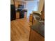 Galley kitchen featuring wood cabinets, granite countertops, black appliances, and wood flooring at 1865 Ellison Lakes Nw Ct # 21, Kennesaw, GA 30152
