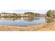 Scenic view of the community pond surrounded by lush trees and natural landscaping at 1865 Ellison Lakes Nw Ct # 21, Kennesaw, GA 30152