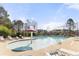 Community pool featuring lounge chairs, umbrellas, and a mushroom shaped water feature at 1865 Ellison Lakes Nw Ct # 21, Kennesaw, GA 30152