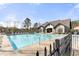 Community pool featuring lounge chairs, umbrellas, and a surrounding fence at 1865 Ellison Lakes Nw Ct # 21, Kennesaw, GA 30152