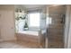 Bright bathroom featuring a soaking tub, shelves and a separate glass-enclosed shower at 3739 In Bloom Way, Auburn, GA 30011