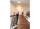 Hallway with wood floors and wrought iron railing, adding style and safety at 3739 In Bloom Way, Auburn, GA 30011
