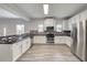 Modern kitchen boasts stainless steel appliances, white cabinets, and a beautiful mosaic backsplash at 3772 Sunbridge Dr, Snellville, GA 30039
