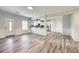 Open-concept living room features laminate flooring, paneled walls, and seamless access to the modern kitchen at 3772 Sunbridge Dr, Snellville, GA 30039