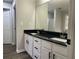 Bathroom with double vanity featuring black granite countertops, new fixtures, and a large mirror at 3920 Knotts Pass Rd, Snellville, GA 30039