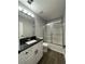 Updated bathroom boasts sleek black countertops, modern vanity, new fixtures and a glass-enclosed shower at 3920 Knotts Pass Rd, Snellville, GA 30039