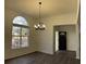 Bright dining room featuring a large arched window, elegant chandelier, and modern flooring at 3920 Knotts Pass Rd, Snellville, GA 30039