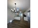 Bright kitchen featuring white cabinets, granite countertops, modern lighting, and wood-look flooring at 3920 Knotts Pass Rd, Snellville, GA 30039