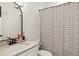 Bathroom with modern black hardware, stylish mirror, and tub with striped shower curtain at 4944 Dovecote Trl, Suwanee, GA 30024