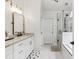 Stylish bathroom boasts marble counters, modern fixtures, and a sleek glass-enclosed shower with black trim at 4944 Dovecote Trl, Suwanee, GA 30024