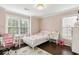 Bright bedroom with pink walls, dark floors, ample natural light, and desk nook for homework at 4944 Dovecote Trl, Suwanee, GA 30024