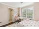 Bright bedroom features a window, desk, and doorway to the ensuite bathroom at 4944 Dovecote Trl, Suwanee, GA 30024