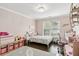 Charming bedroom with pink walls, dark floors, a bunny rug, and a large window for natural light at 4944 Dovecote Trl, Suwanee, GA 30024