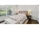 Cozy bedroom features hardwood floors, large window, and shiplap accent wall at 4944 Dovecote Trl, Suwanee, GA 30024