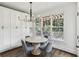Dining area with large windows, modern chandelier, and storage cabinets provides an inviting space at 4944 Dovecote Trl, Suwanee, GA 30024