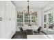 Dining area with large windows, modern chandelier, and doors leading to the yard at 4944 Dovecote Trl, Suwanee, GA 30024