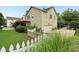 View of the home's exterior with a well-maintained lawn, white picket fence, and attached garage at 4944 Dovecote Trl, Suwanee, GA 30024