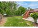 Spacious backyard with green grass and a wooden deck with stairs at 980 Charter Club Dr, Lawrenceville, GA 30043