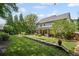 A landscaped backyard with a stone retaining wall, patio, lush greenery, and mature trees at 1059 Rockford Township Sw Dr, Marietta, GA 30064
