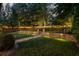 Night view of a landscaped backyard, featuring a stone retaining wall and string lights at 1059 Rockford Township Sw Dr, Marietta, GA 30064