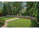 Landscaped backyard with a stone retaining wall and a lush lawn with trees and plants at 1059 Rockford Township Sw Dr, Marietta, GA 30064