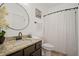 Bright bathroom featuring a granite vanity, black hardware, round mirror, and walk-in shower with white shower curtain at 1059 Rockford Township Sw Dr, Marietta, GA 30064