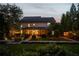 Exterior rear view of two-story home with a covered patio, large trees, and landscape lighting at 1059 Rockford Township Sw Dr, Marietta, GA 30064